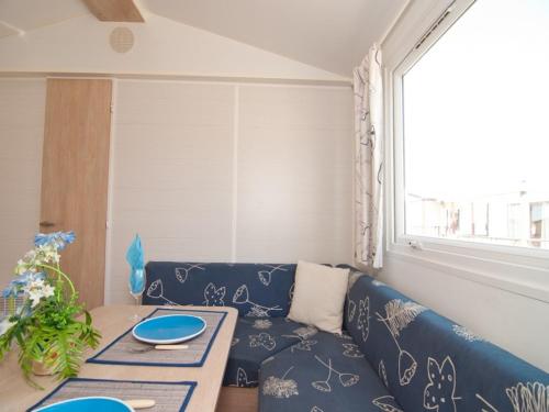 sala de estar con sofá azul y mesa en Camping Derby Loredo, en Loredo