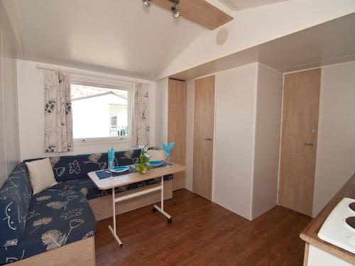 a living room with a couch and a desk in it at Camping Mola! Surf Loredo in Loredo