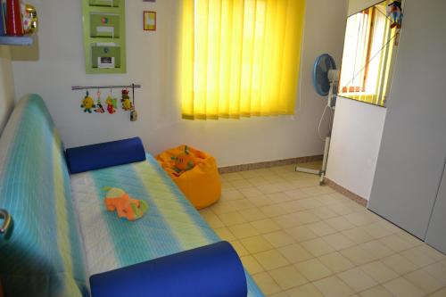 a bedroom with a bed and a yellow curtain at Mary&Kate's green house in Scalea