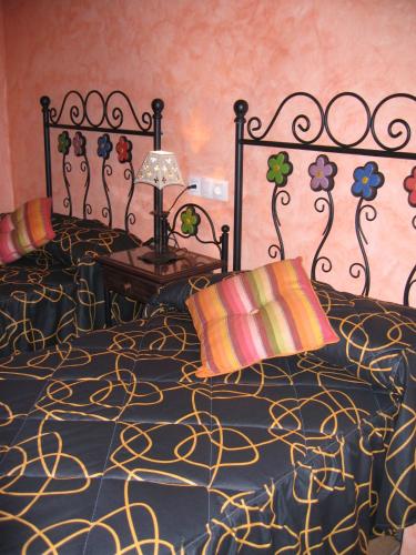 a bedroom with a black and gold bed with a lamp at Casa Herrero in Oto