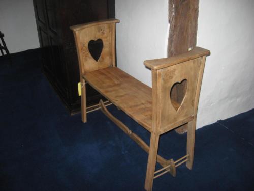 a wooden chair with hearts on it sitting in a room at Walford Court in Leintwardine