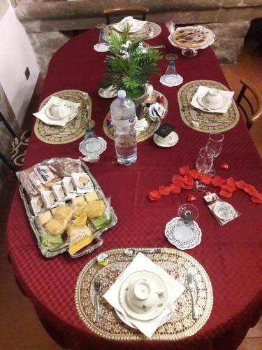 a red table with plates of food on it at Alloggio Turistico "L'Incontro" 6 in Viterbo