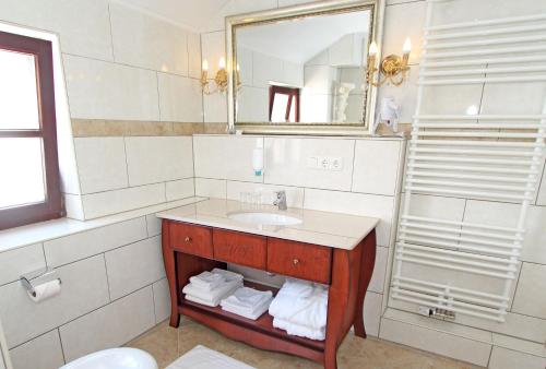 y baño con lavabo y espejo. en Hotel Villa Toscana, en Gersthofen