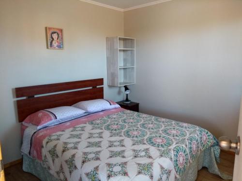 a bedroom with a bed with a quilt on it at Hostal Maria Casa in La Serena