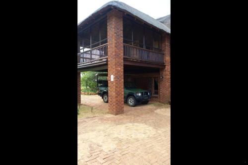 a brick house with a car parked in the driveway at Hadeda Lodge, Mabalingwe in Warmbaths