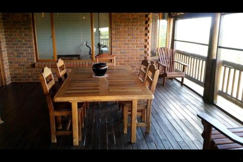 a wooden table and chairs on a deck with a table at Hadeda Lodge, Mabalingwe in Warmbaths