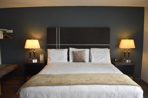 a bedroom with a large bed with two lamps at Lull-Abi Inn in Egg Harbor