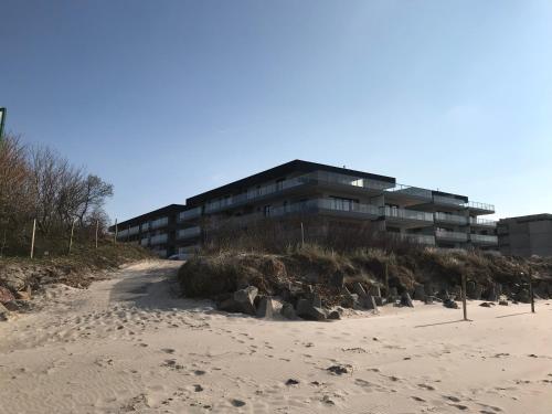 a building on the beach next to a beach at Apartament FAMILY Gardenia Dziwnów in Dziwnów