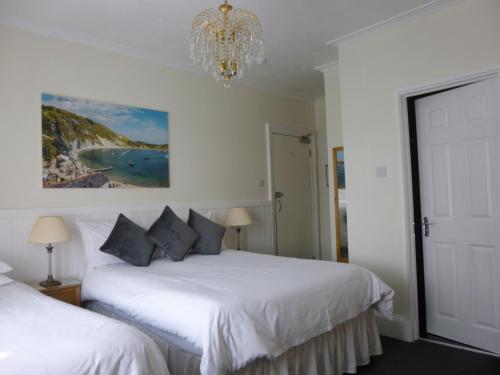 a bedroom with two white beds and a chandelier at Southernhay Guest House in Bournemouth