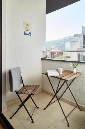 a chair and a table in a room with a window at Moodeight Apartments in Skopje
