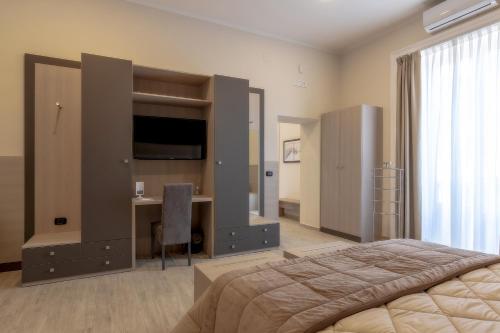 - une chambre avec un lit, un bureau et une télévision dans l'établissement B&B Mariella's House, à Santa Maria Capua Vetere