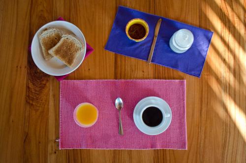 a table with a plate of bread and a cup of coffee at Hotel Vista de Olas in Santa Teresa Beach