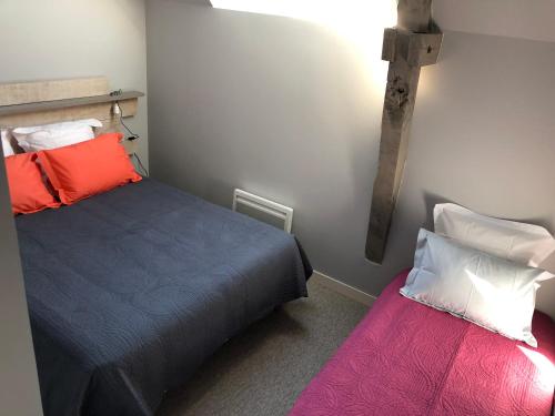 a bedroom with two beds and a cross on the wall at Gîte de la Huppe in Noyers-sur-Cher