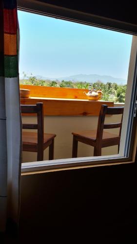 a view of a table and two chairs through a window at Hotel Alebrijes in San Pedro Pochutla