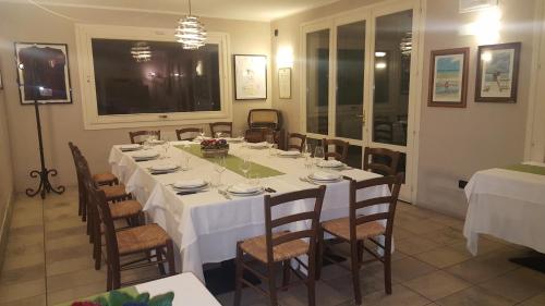 a dining room with a long table with white table cloth at Casa Selene Rocchi in Savignano sul Panaro