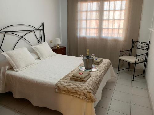 um quarto com uma cama com uma vela e uma cadeira em Apartamento Sol em Alcalá