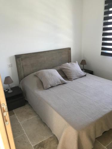ein Schlafzimmer mit einem Bett mit zwei Kissen darauf in der Unterkunft Charmante maison de village *** in Santa-Maria-Figaniella
