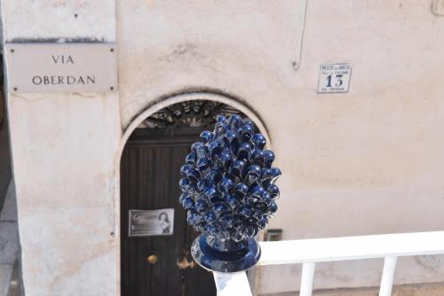 a blue glass vase sitting in front of a building at Casa Mida - Guest House in Pezze di Greco