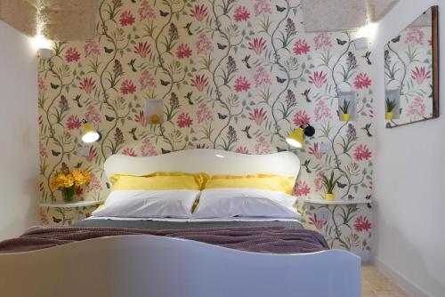a bedroom with a bed with a floral wallpaper at Casa Mida - Guest House in Pezze di Greco