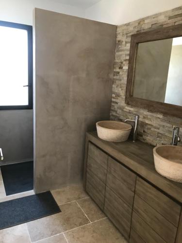 ein Badezimmer mit zwei Waschbecken und einem Spiegel in der Unterkunft Charmante maison de village *** in Santa-Maria-Figaniella