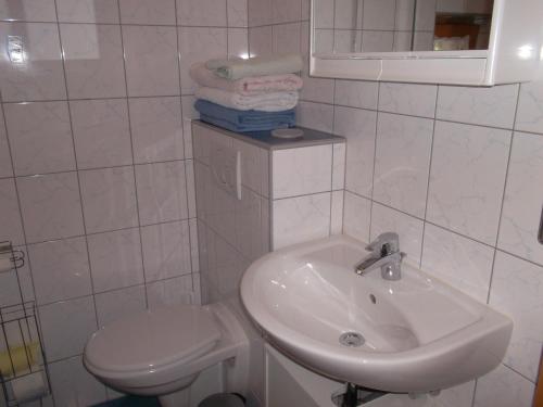 a white bathroom with a sink and a toilet at Riepleralm in Matrei in Osttirol