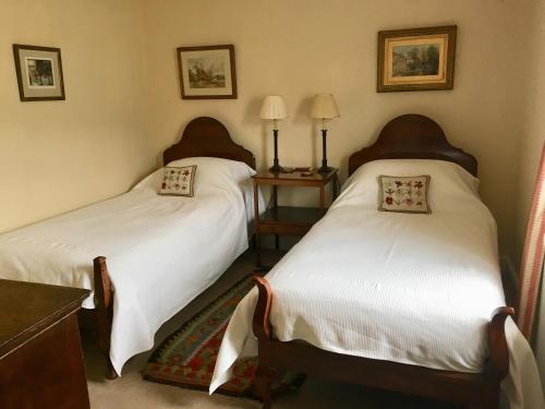 2 camas en una habitación con sábanas blancas en 34 Grosvenor Drive, en Tisbury