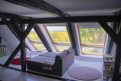 a living room with a couch and two windows at Panorama-Loft Fehmarn mit Meerblick in Fehmarn