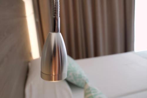 a silver lamp sitting on top of a bed at Hotel Vista Odin in Playa de Palma