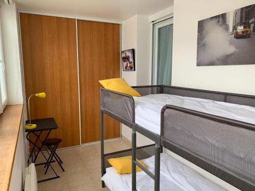 sypialnia z łóżkiem piętrowym i biurkiem w obiekcie Appartement cosy proche plage et centre ville w mieście Granville