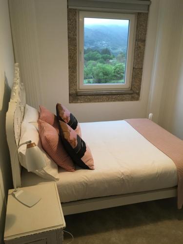 uma cama num quarto com uma janela em Casa do Giraldo - Alojamento Local em Arcos de Valdevez