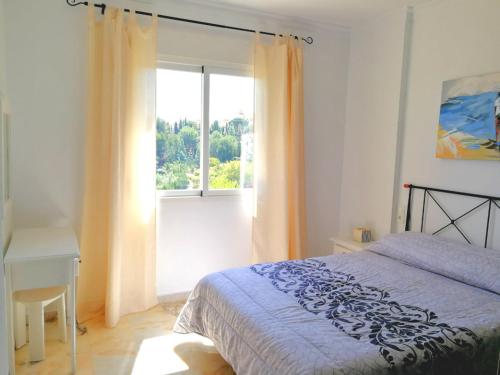 1 dormitorio con cama y ventana en Benalmarina Sea View Apartments, en Benalmádena