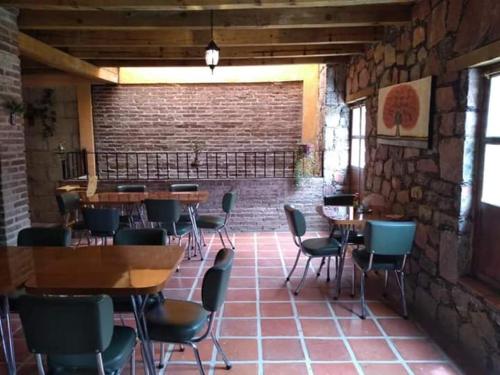 a restaurant with tables and chairs and a brick wall at Hotel San Pancho in Real de Catorce