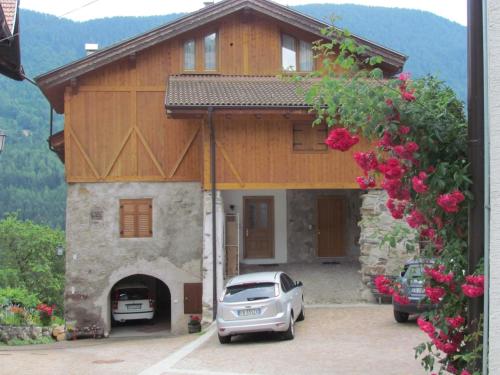 a house with a car parked in front of it at Appartamenti Rumo in Rumo