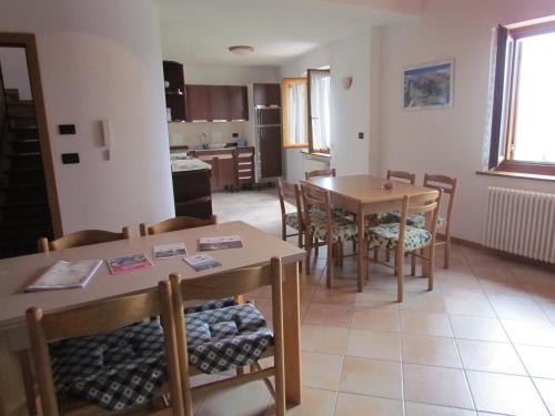 a kitchen and dining room with two tables and chairs at Appartamenti Rumo in Rumo