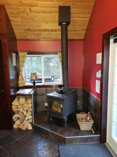 a wood stove in a room with red walls at Cedar House Restaurant & Chalets in Golden