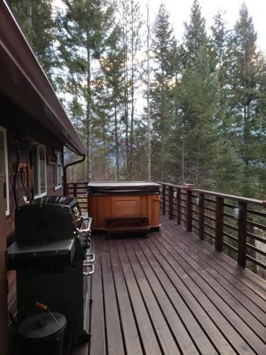 a deck with a hot tub and a grill at Cedar House Restaurant & Chalets in Golden