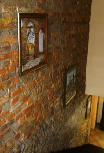 a brick wall with two pictures on it at Kontiki Hotel in São Francisco do Sul