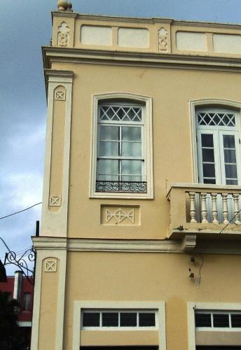 a building with two windows and a balcony at Kontiki Hotel in São Francisco do Sul