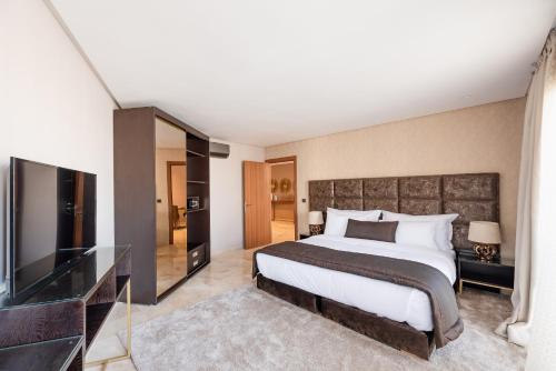 
a bedroom with a bed and a dresser at Hotel Avenue Suites Deluxe in Casablanca
