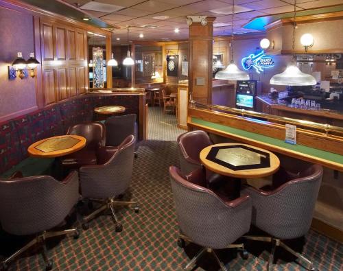 a bar with chairs and tables in a restaurant at Ramkota Hotel - Casper in Casper
