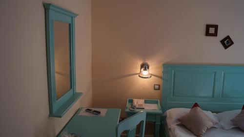 a bedroom with a bed and a table and a lamp at Hotel Bastion in Sinaia