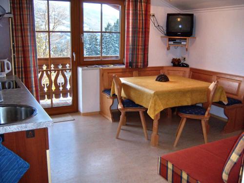 a kitchen with a table and a television in it at Appartement zum Rössl in Ramsau am Dachstein