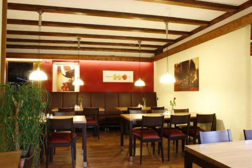 une salle à manger avec des tables, des chaises et des lumières dans l'établissement Saaletal Pension & Ferienwohnungen, à Bad Bocklet