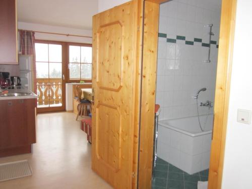 baño con puerta de madera y bañera en Appartement zum Rössl, en Ramsau am Dachstein