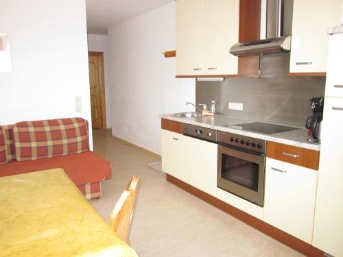 a kitchen with a stove and a table in it at Appartement zum Rössl in Ramsau am Dachstein