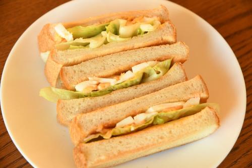 three sandwiches on a white plate on a table at ファミリー不向き!!素泊まり一棟貸切りではない個室の静かな方限定無料WiFi in Irumagawa