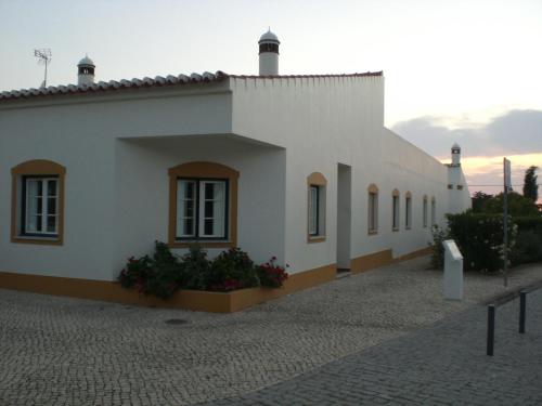 un edificio blanco con algunas plantas delante de él en Hotel Pulo do Lobo, en Serpa