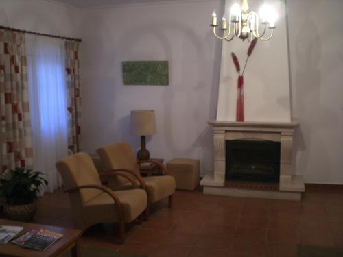 a living room with two chairs and a fireplace at Hotel Pulo do Lobo in Serpa