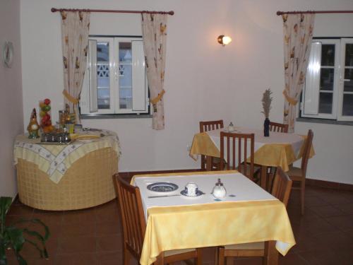 a dining room with two tables and a yellow table cloth at Hotel Pulo do Lobo in Serpa
