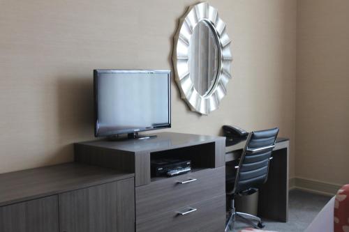 a room with a tv and a chair and a mirror at Opera House Hotel in Bronx